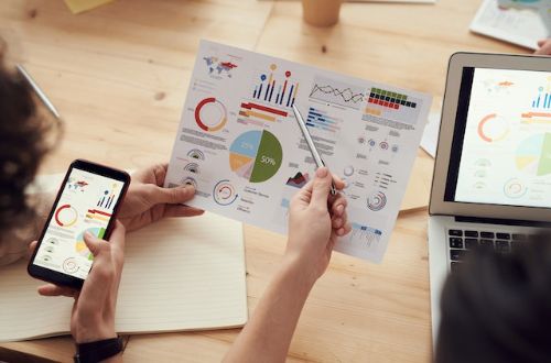 A professional holding up a sheet of paper with graphs and bar charts